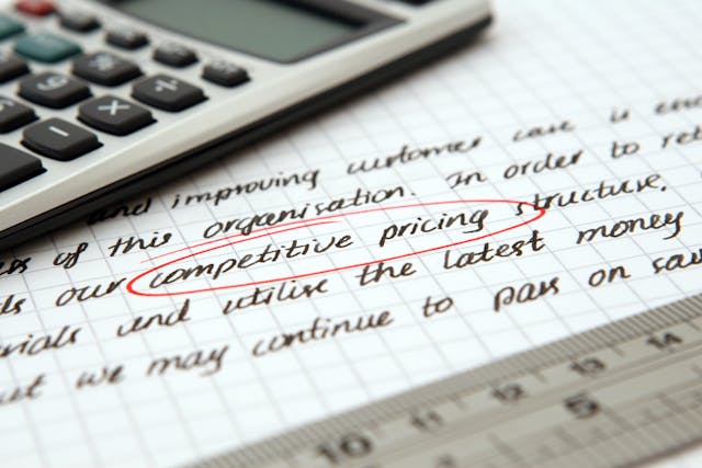 calculator laid down on a paper with "competitive pricing" circled in red