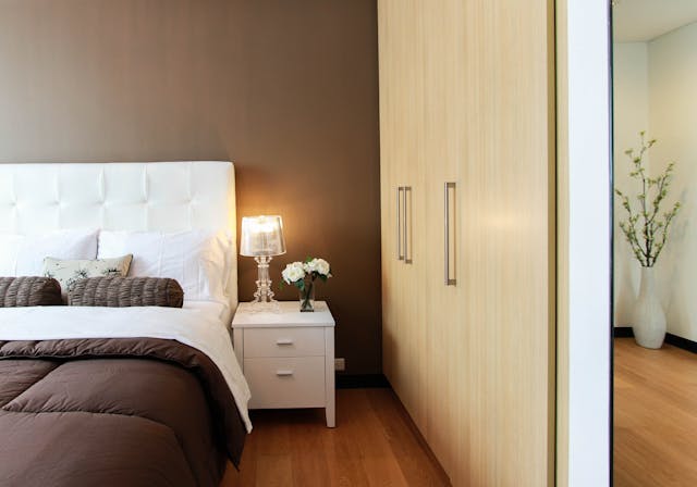 a bedroom with brown walls and built in storage