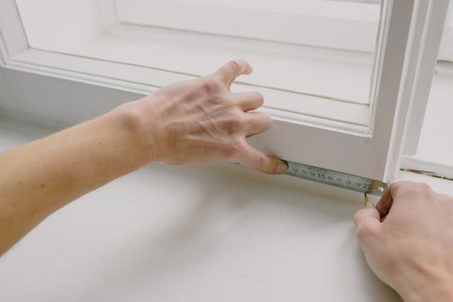 person measuring a windowsill