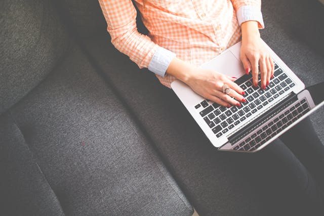 person sitting on couch using laptop
