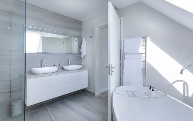 a modern white bathroom with a double vanity