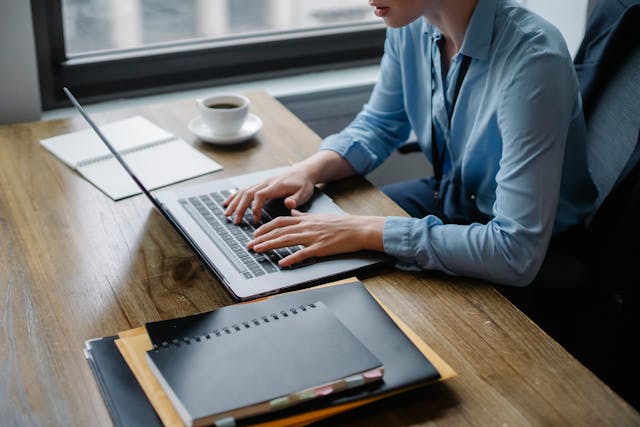 person sitting at their desk working on their computer