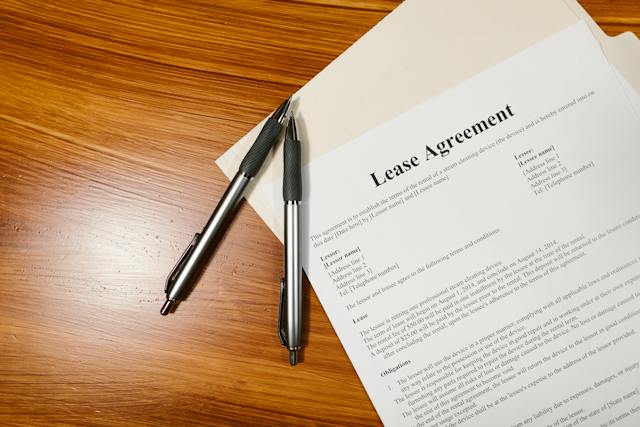 a lease agreement document with two pens resting on top of it