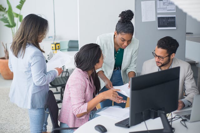 a group of employees working at a desk together