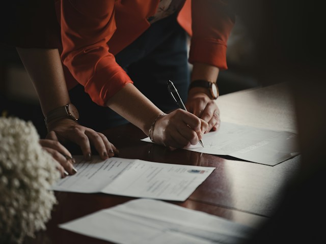 a landlord overseeing a tenant signing a lease agreement