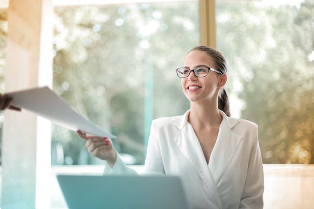 person smiling while being handed a document