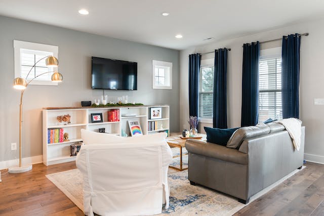 a living room with a grey couch and white lounge chair