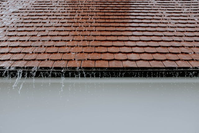 rainwater running off a roof into a home's gutter