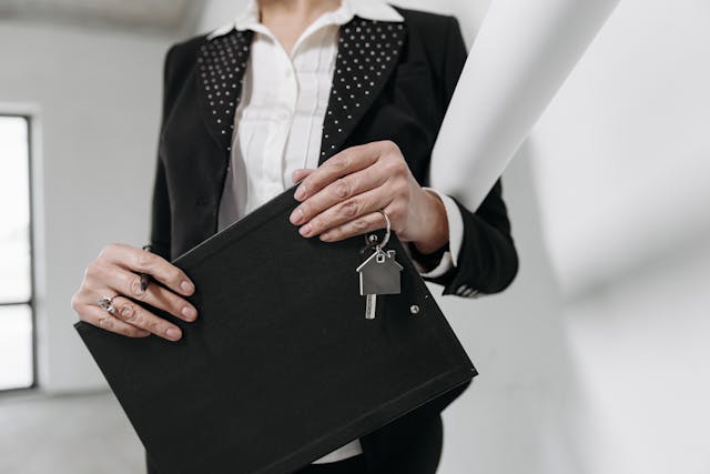 a real estate agent holding a folder and a set of house keys