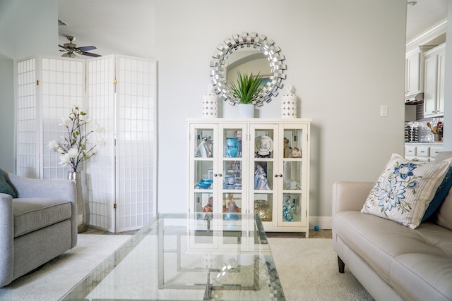 living room with a glass coffee table and two beige couches facing each other