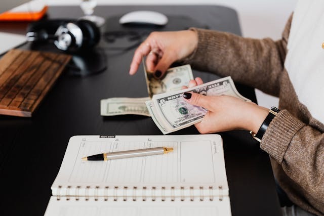 Landlady sitting at a table counting money